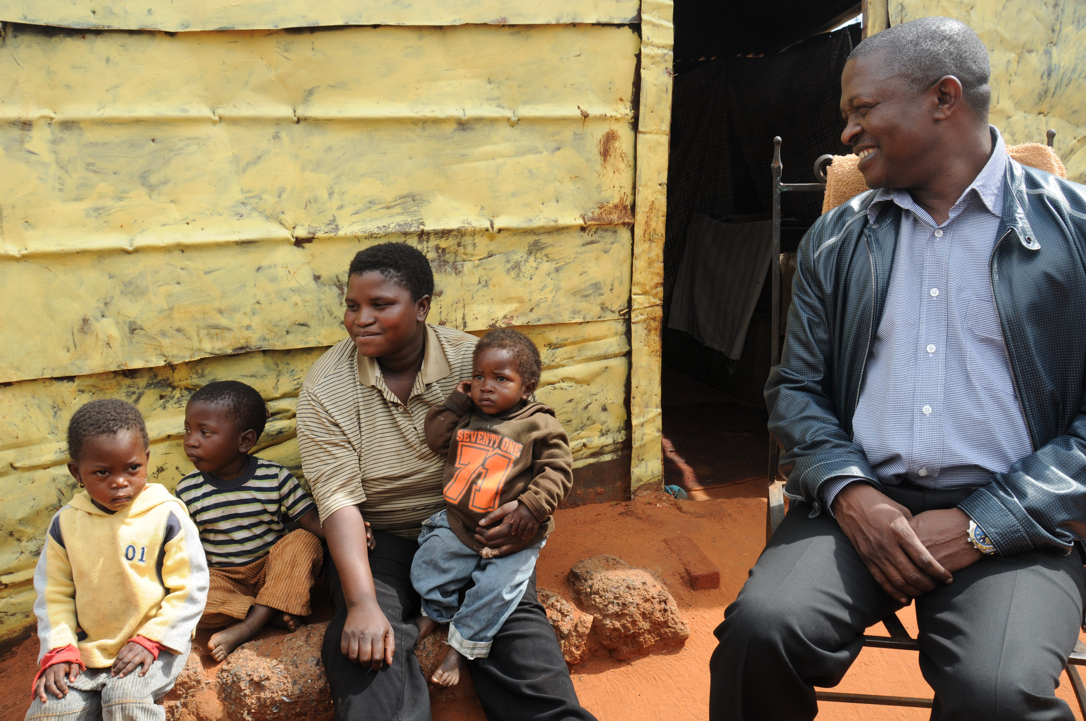 Mpumalanga Premier David Mabuza sits in front of a shack with Ms Annah Marakalala.